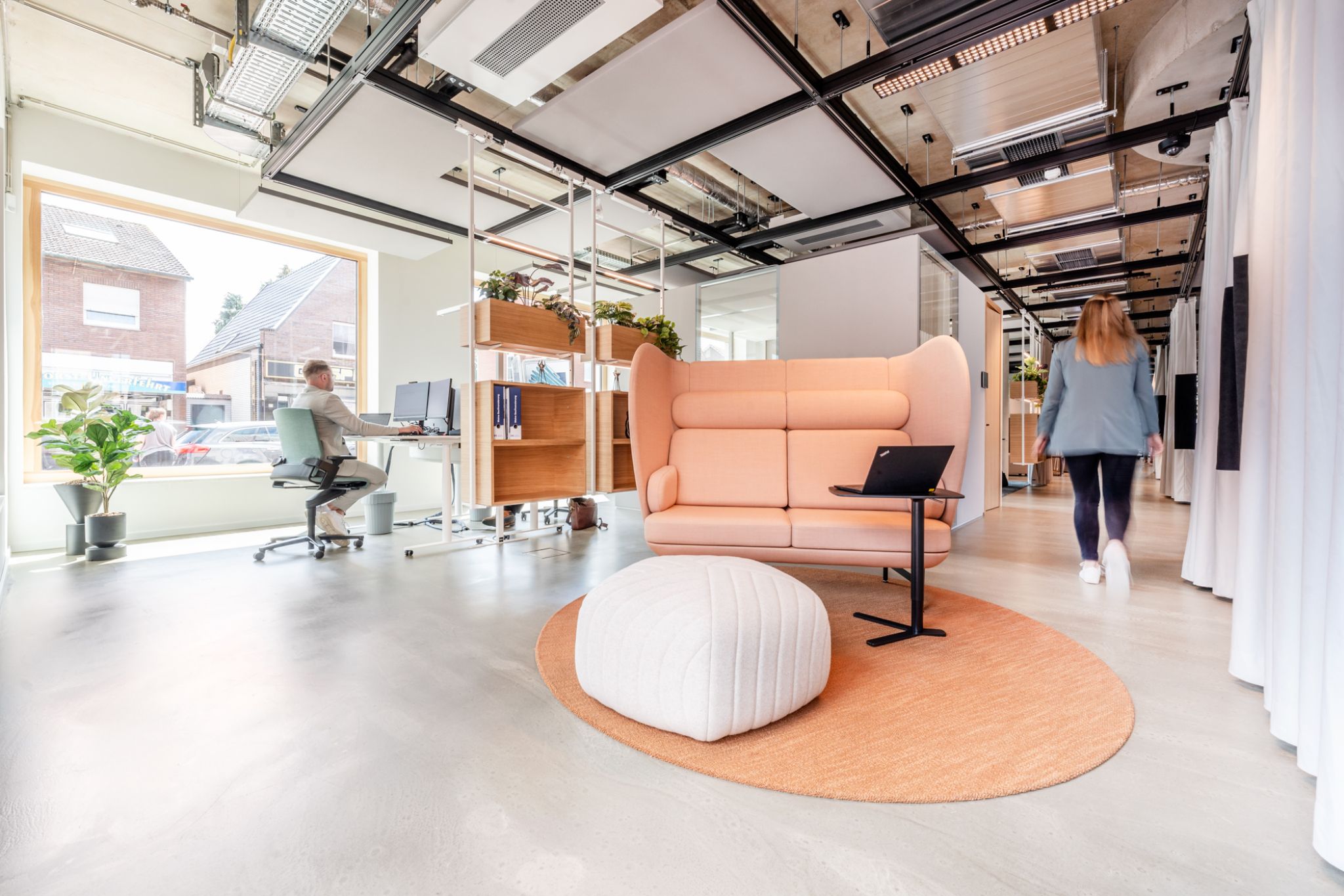 Modernes, minimalistisches Innenraumdesign der B&uuml;ror&auml;ume  einer Bankfiliale mit eleganter Beleuchtung und hellen W&auml;nden und eine schwebende Deckenstruktur, eingerichtet von Visplay f&uuml;r die Grafschafter Volksbank.