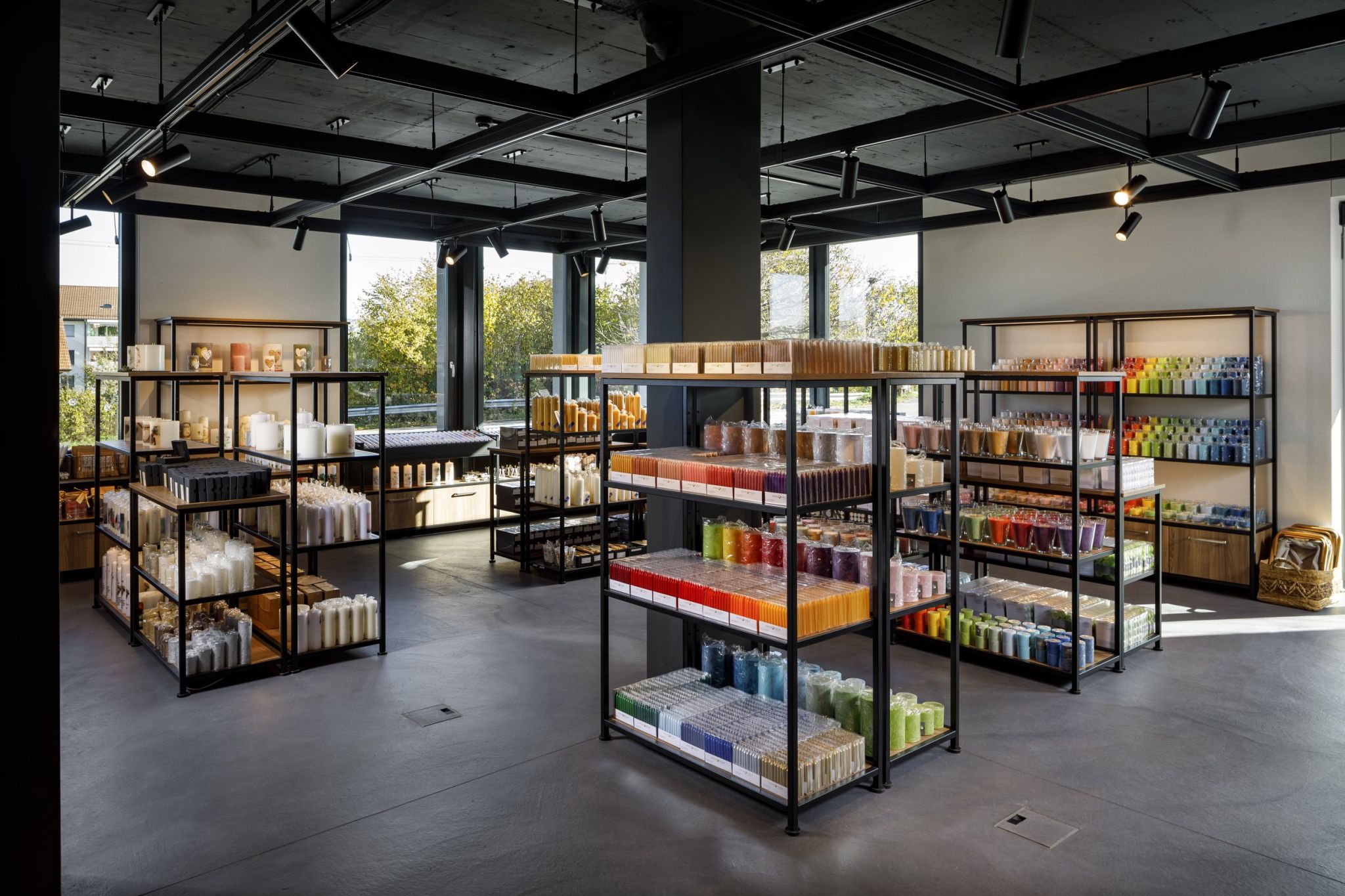 Vue int&eacute;rieure de la manufacture de bougies HERZOG &eacute;quip&eacute;e de syst&egrave;mes d'&eacute;tag&egrave;res Visplay's sur lesquels les bougies sont pr&eacute;sent&eacute;es.