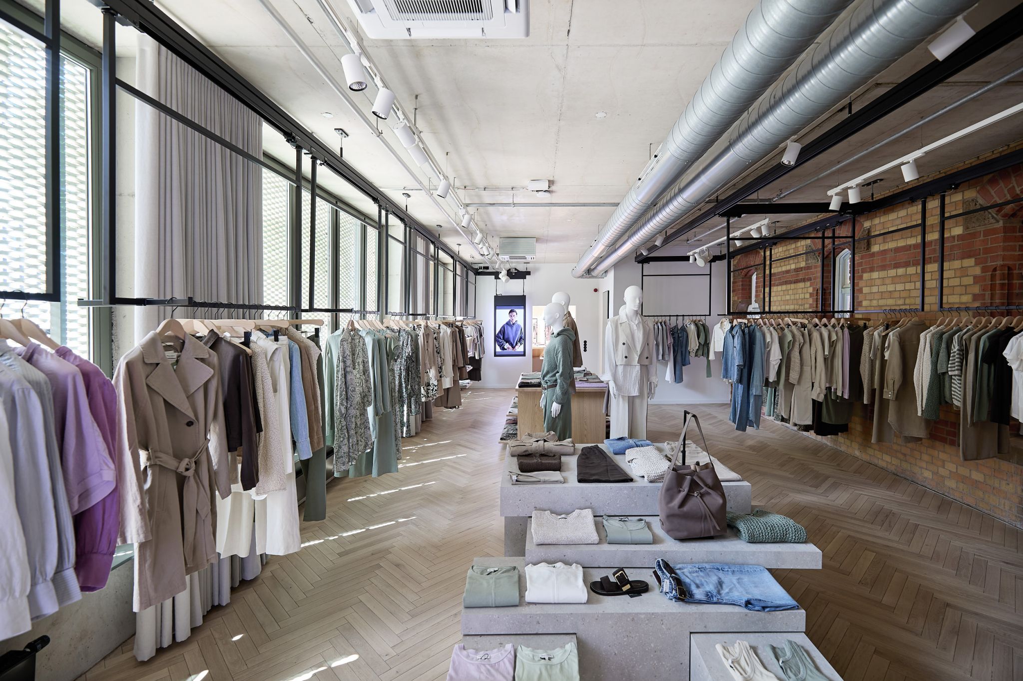 Marc O'Polo Showroom mit deckenmontierten Warentr&auml;gern als flexible Pr&auml;sentationsl&ouml;sung f&uuml;r H&auml;ngeware.