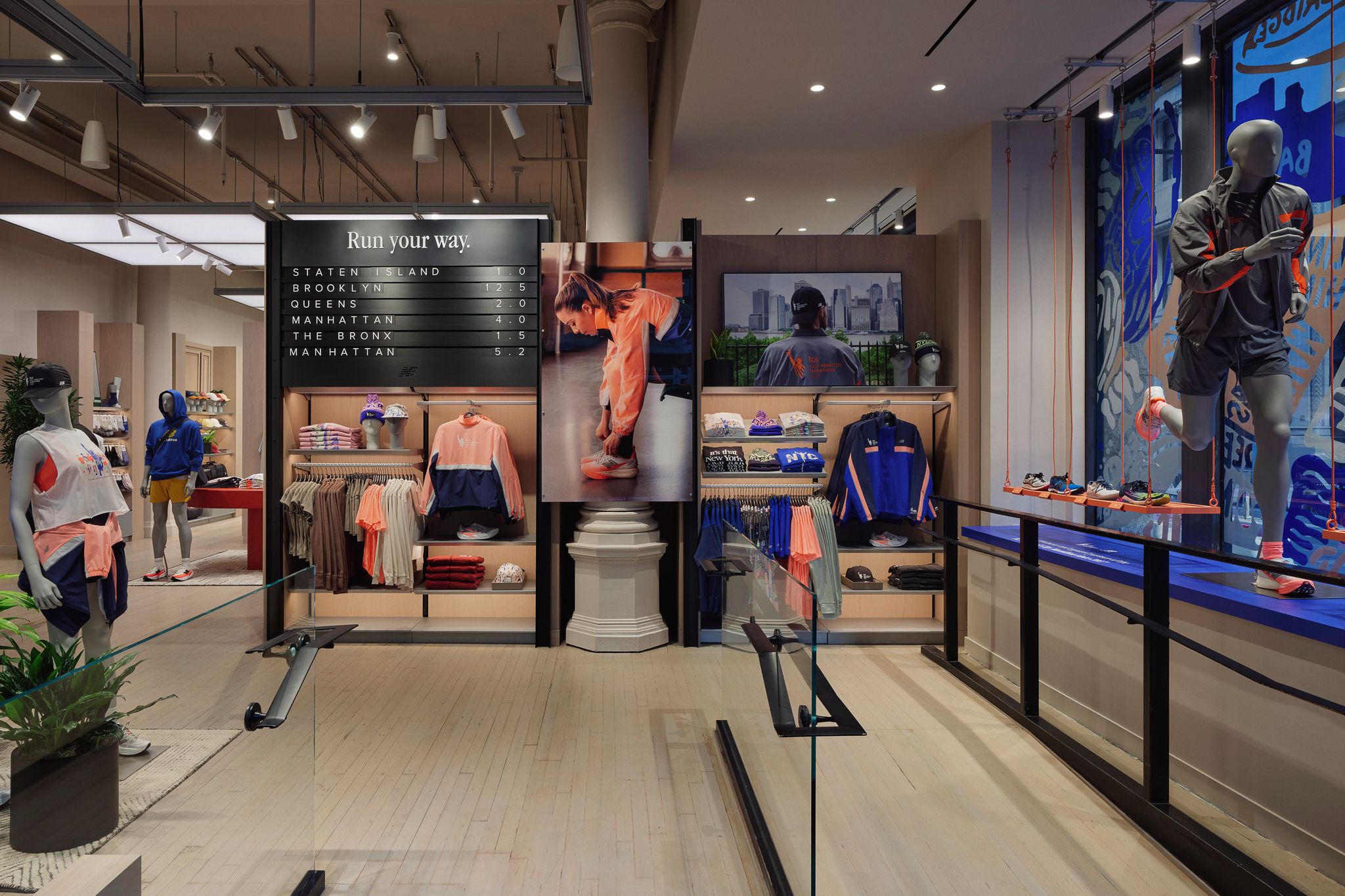 Interior de tienda con ropa deportiva, estantes con su&eacute;teres doblados, cintas de correr y maniqu&iacute; con ropa deportiva.