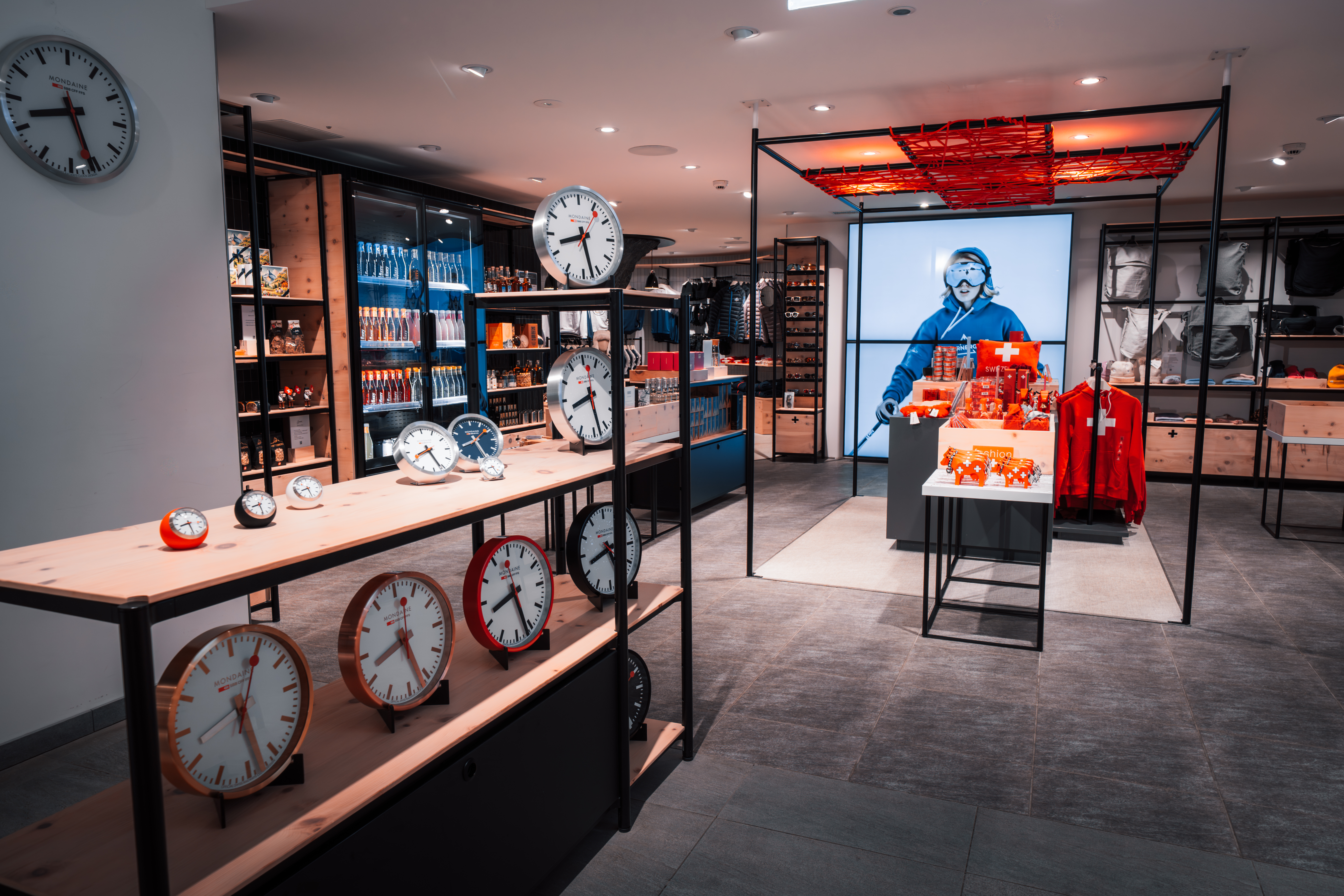 Verkaufsraum mit Regalen voller Uhren und einem Schaufenster mit Schweizer Souvenirs und einer Schaufensterpuppe