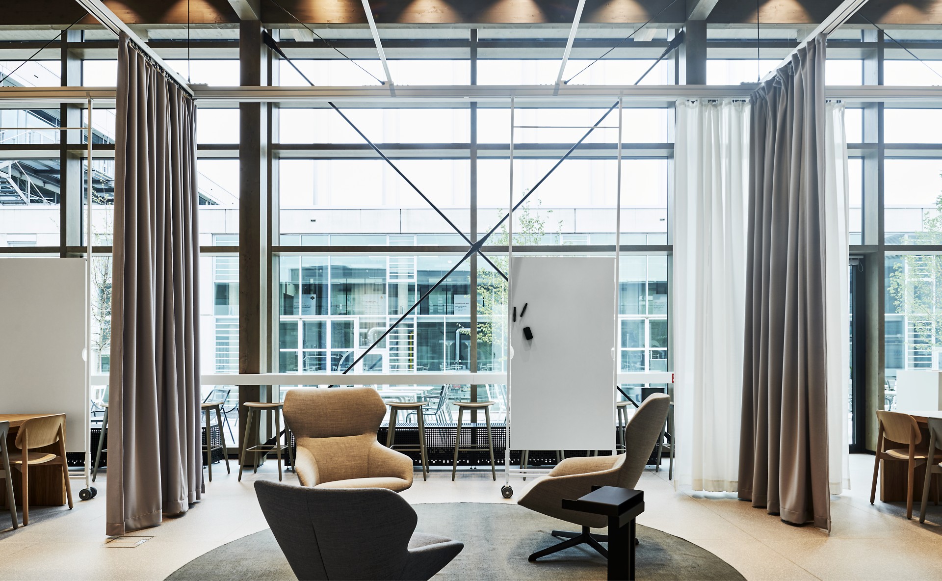 Raum mit einem Sitzbereich und von der Decke h&auml;ngenden Whiteboards.