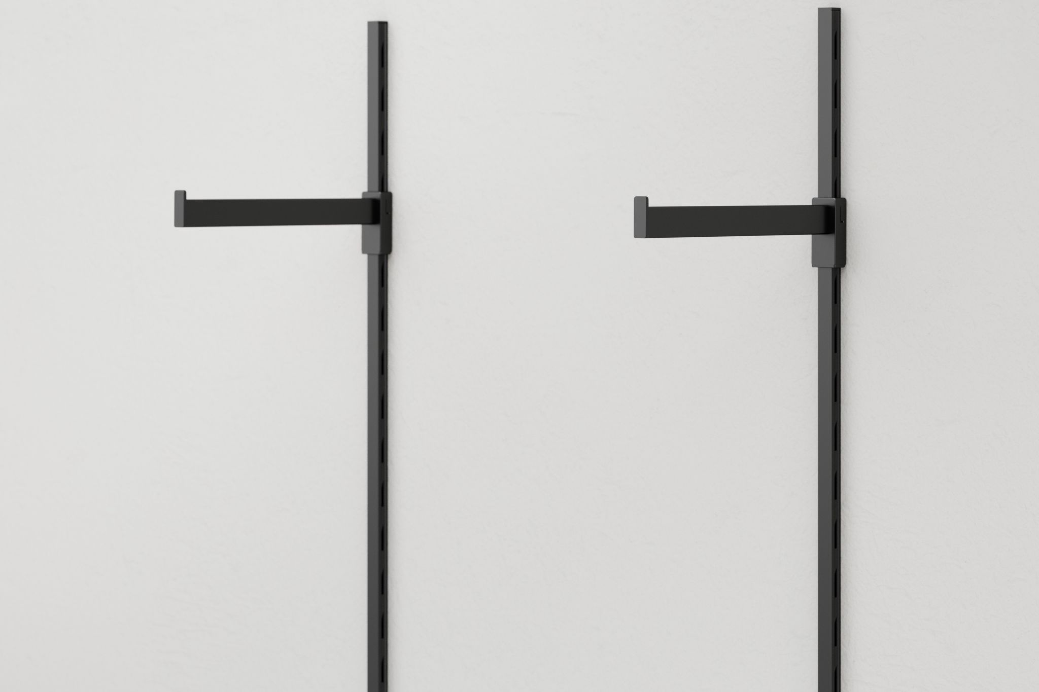Deux bras porte-marchandises noirs fix&eacute;s &agrave; un syst&egrave;me mural avec des rails verticaux sur fond blanc