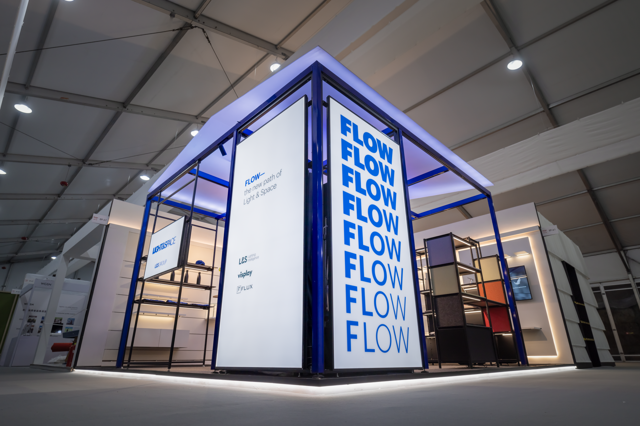 Exhibition booth with illuminated frame and large displays showing the word 'FLOW' repeated in blue letters