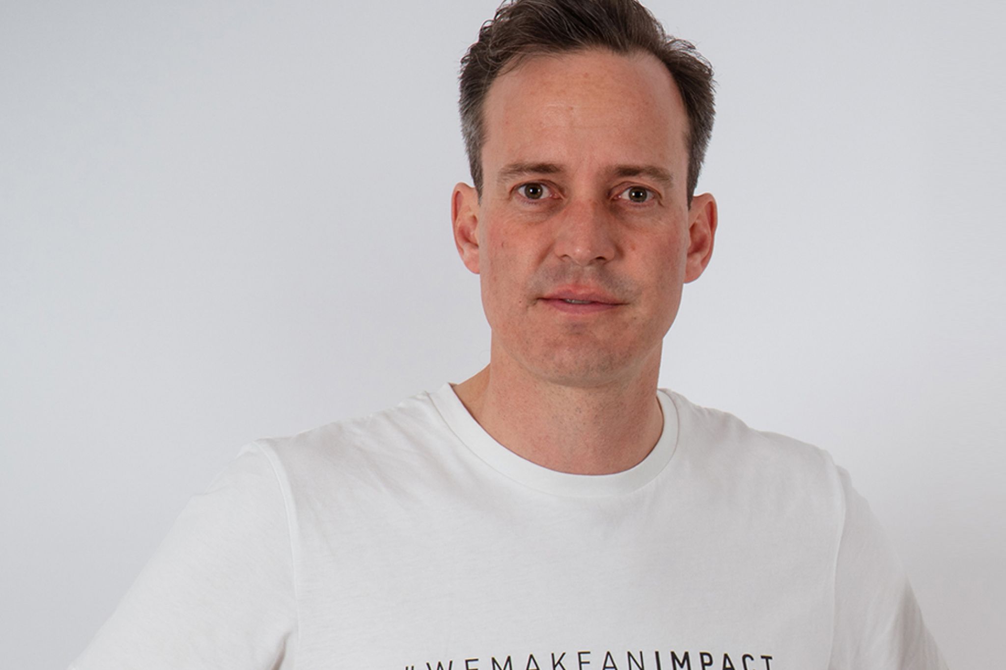 Mann mit dunklen Haaren in einem wei&szlig;en T-Shirt.