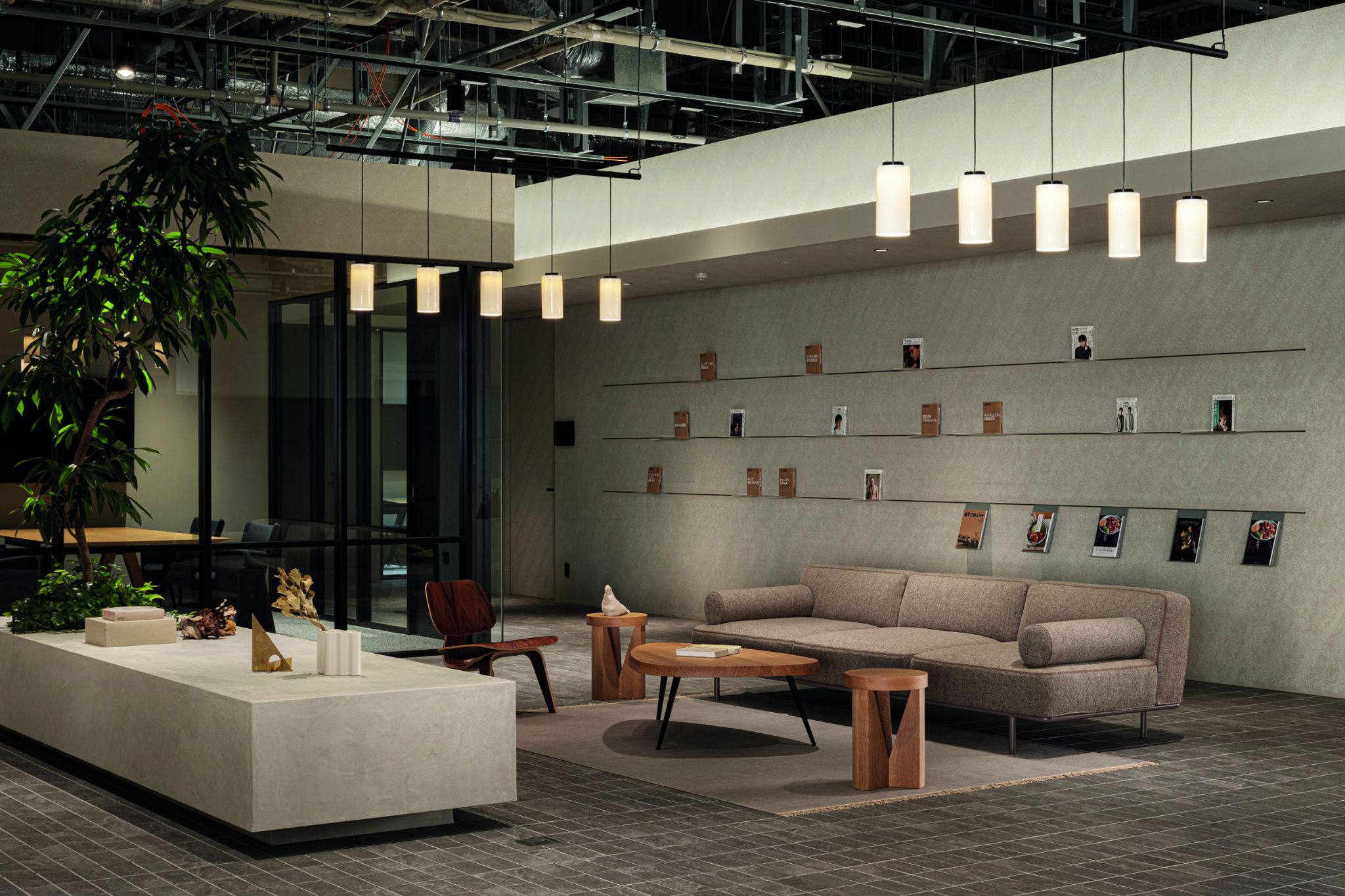 Moderner Lounge-Bereich mit grauem Sofa, Holz-Couchtisch, St&uuml;hlen, Pflanzen und beleuchteter Decke.