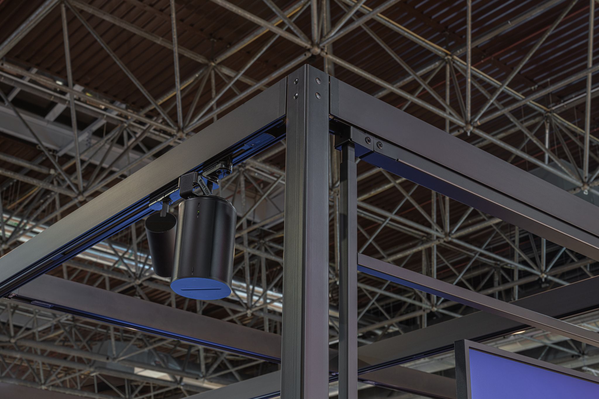 Nahaufnahme einer schwarzen Metallrahmenkonstruktion mit sichtbaren Schrauben und einem zylindrischen Bauteil